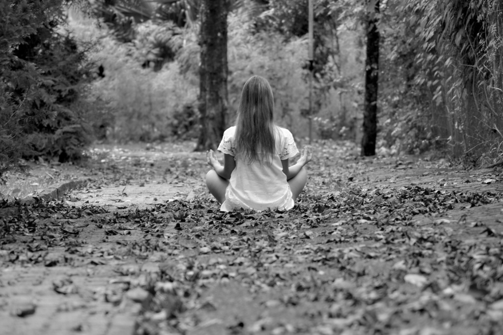 Fille assise de dos dans la forêt - image en noir&blanc
